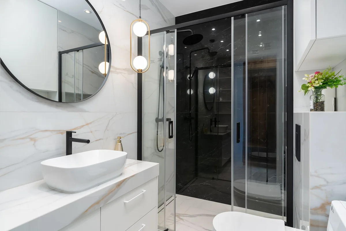Modern bathroom with mirror, pendant and recessed lighting